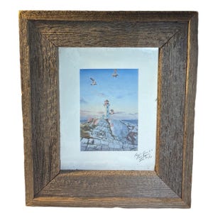 May include: Framed print of a lighthouse on a rocky coast under a blue sky with seagulls. The artwork is in a white mat and set in a rustic, weathered wood frame. The print has a signature and date.