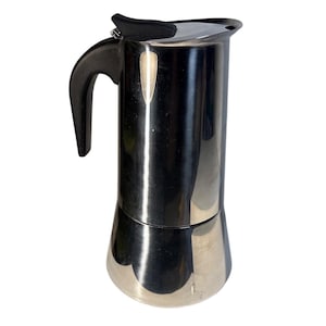 Pode incluir: Uma cafeteira de fogão em aço inoxidável com uma alça e tampa pretas. A cafeteira tem um corpo cilíndrico com uma base alargada e uma tampa articulada. A alça é curva e presa à lateral.