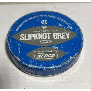 May include: A round, blue metal container of "SLIPKNOT GREY" vinyl plastic electrical tape. The container has the text "PREMIUM PERFORMANCE VINYL PLASTIC ELECTRICAL TAPE" and "72'" printed on it. The tape is 3/4 in x 0.007 in x 72 Ft.