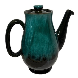 May include: A teal and black ceramic teapot with a lid, handle, and spout. The teapot has a glossy finish and a rounded body. The handle is a large, curved loop, and the spout is long and slender.