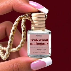 May include: A small clear glass oil diffuser bottle with a light wood cap and a beige hanging cord. The label reads femme luxe, teakwood mahogany, mahogany | musk | oak | citrus | lavender | rose, OIL DIFFUSER, and 0.33 FL. OZ (10 ML).
