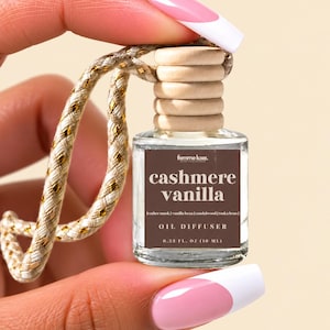 May include: A small clear glass oil diffuser bottle with a wooden cap and a braided gold and white hanging cord. The brown label reads femme luxe, cashmere vanilla, leather musk, vanilla bean, sandalwood, tonka bean, OIL DIFFUSER, 0.33 FL. OZ (10 ML).