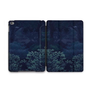 May include: A dark blue iPad case with a forest scene featuring trees and leaves. The case is closed and has a flap that folds over the front.