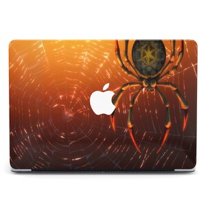 Pode incluir: Uma capa para laptop com um design de teia de aranha e uma grande aranha no centro. A aranha é laranja e preta com um abdômen vermelho. O fundo é um degradado de laranja e marrom.