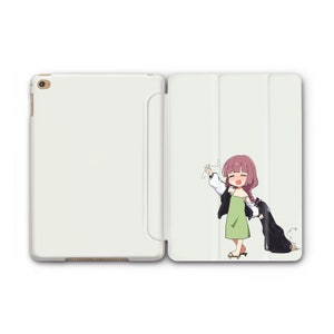 Puede incluir: Una funda blanca para iPad con una ilustración de dibujos animados de una niña con cabello rosado que lleva un vestido verde y una chaqueta blanca. La niña está saludando con la mano derecha y sosteniendo una chaqueta negra en la mano izquierda.