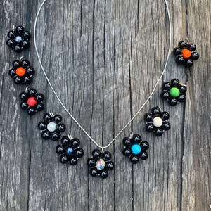 Beautiful shiny black with faux hewlite bead flower pendant on silver necklace