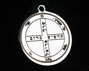 Puede incluir: Un colgante circular de metal plateado con un diseño de cruz central y grabados en hebreo de color negro. El borde exterior contiene texto adicional en hebreo y un pequeño símbolo de la Estrella de David en la parte superior.