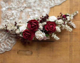 Bridal headdress in burgundy tones with matching boutoniere also in burgundy.