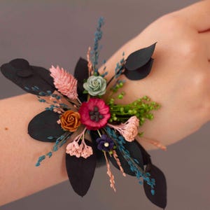 Corsage invernale con eucalipto blu, fiori secchi e fiori di carta in rosa antico, bordeaux e blu navy