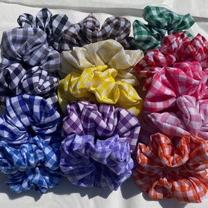 May include: A set of 10 colourful gingham hair scrunchies in various colours, including blue, purple, yellow, green, red, and black.