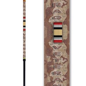May include: A black and brown walking stick with a camouflage pattern and the words "Iraq Veteran" printed on it. The stick is adjustable and has a rubber tip.