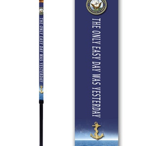 May include: A navy blue walking stick with a gold anchor and the text "The only easy day was yesterday". The stick has a black handle and a black tip. The stick is decorated with a navy blue and white pattern.