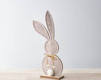 Cute felt bunny perched upon a natural wooden base with a beaded double bow with pom pom tail in neutral colours
