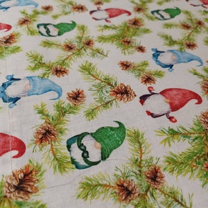 May include: White fabric with a repeating pattern of green pine branches, brown pine cones, and gnomes with red, blue, and green hats.