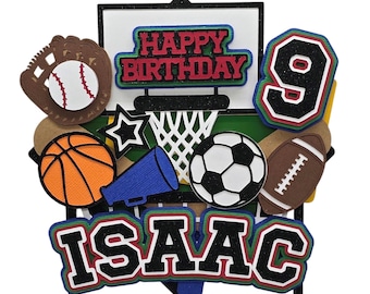 Puede incluir: Un adorno para tarta de cumpleaños colorido con recortes temáticos deportivos. Incluye una pelota de baloncesto, un guante de béisbol con pelota, un balón de fútbol, un balón de fútbol americano y el número 9. El adorno también tiene las palabras "Happy Birthday" y el nombre "Isaac".