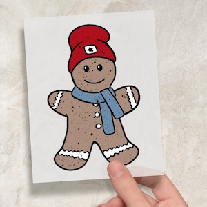 Op de afbeelding: Illustratie van een peperkoekmannetje met een rode muts met een witte ster, een blauwe sjaal en witte rand. Het peperkoekmannetje heeft een lachend gezicht en drie witte knopen. De afbeelding staat op een witte kaart.