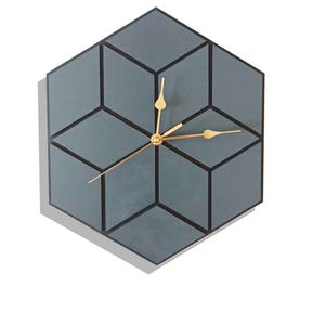 May include: A contemporary wall clock featuring a geometric design. The clock face is hexagonal, with a grey and black colour scheme. The clock hands are gold-coloured.