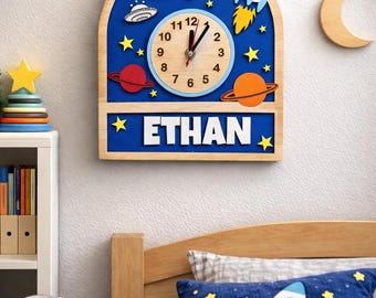 Reloj de pared con temática espacial / Nombre personalizado, astronauta, cohete y decoración de planetas / Arte para habitación infantil espacial / Ayuda para aprender el tiempo