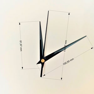 May include: Black clock hands with gold accents. The minute hand measures 118.57 mm, the hour hand measures 81.97 mm, and the second hand measures 100.50 mm.