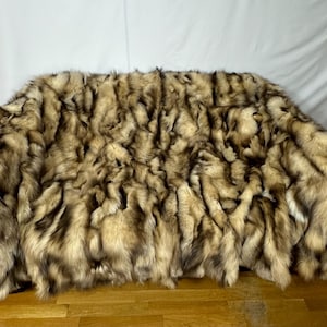 May include: A luxurious faux fur throw blanket in a brown and cream color with a long, shaggy pile.