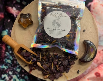May include: A small clear plastic bag filled with a purple bath soak labeled "Full Moon Bath Soak" with the text "Flower in bath, soak & relax" and a list of ingredients.