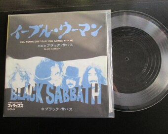 May include: A black and white record sleeve with a photo of the band Black Sabbath. The text on the sleeve reads "Evil Woman Don't Play Your Games With Me" and "Black Sabbath".