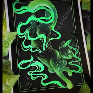 Pu&ograve; includere: Un gatto verde con scie di fumo verde incandescente dietro di lui. Il gatto &egrave; su uno sfondo nero con il testo "Zomligo Designs" in bianco.
