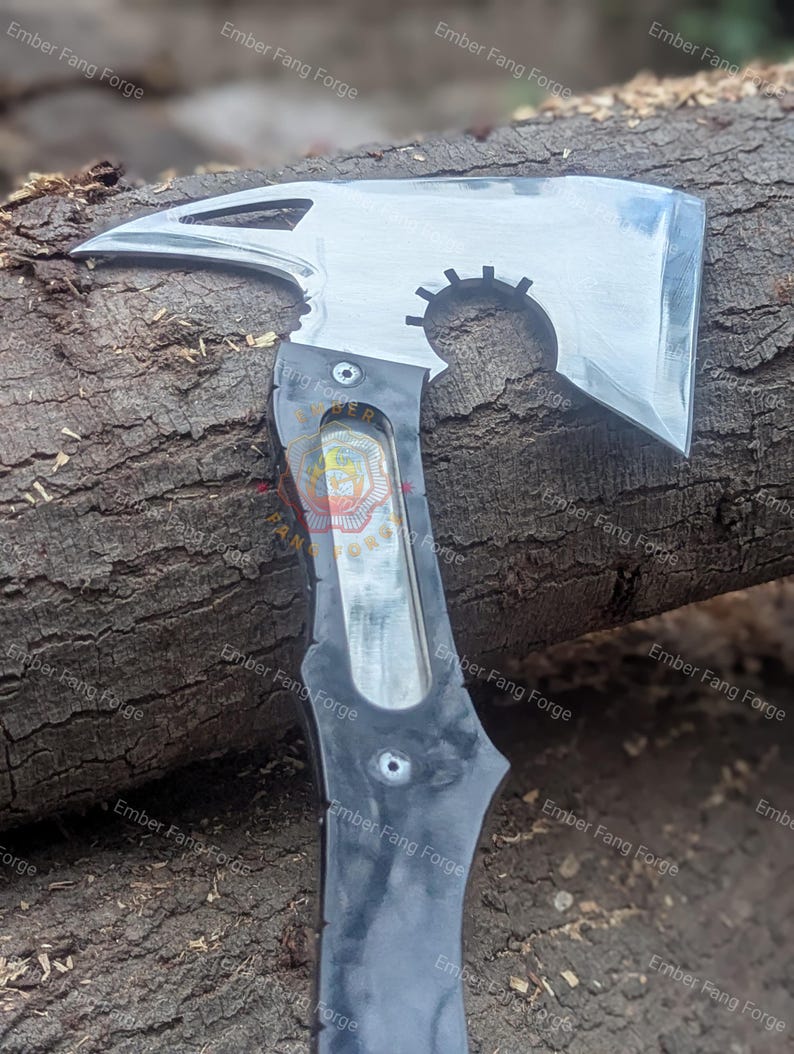 May include: A polished steel axe with a black handle. The axe head features a sharp blade, a pointed spike, and a circular cutout. The handle has a curved design and is riveted to the axe head. The axe is designed for utility and display.