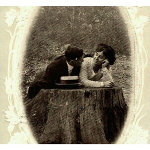 Puede incluir: Una fotografía vintage en blanco y negro de una pareja sentada en un tocón de árbol. La mujer está apoyada en su mano y mirando al hombre. El hombre está mirando a la mujer y tiene su sombrero en su regazo.