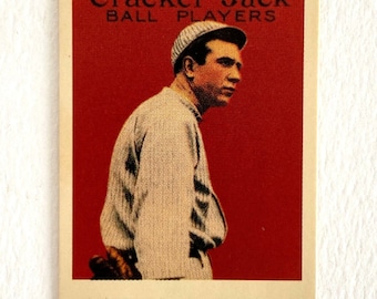 May include: A vintage Cracker Jack baseball card featuring a baseball player wearing a white jersey and a white cap. The card has a red background with the text "Cracker Jack Ball Players" at the top and "SPEAKER, BOSTON - AMERICANS" at the bottom.