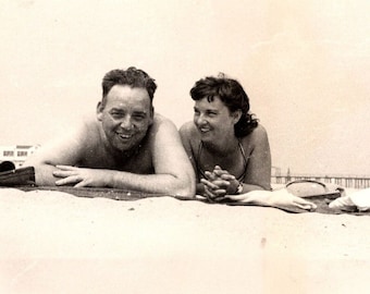 1947 Vintage Man and Woman Lying in the Sand on Beach Near Pier Photograph