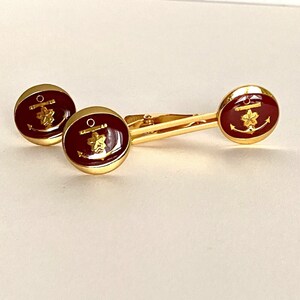 以下が含まれることがあります： 赤いエナメルと金の錨と星のデザインが施された、金色のネクタイピン2個セットです。