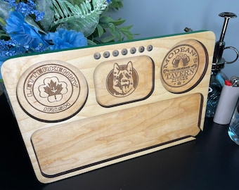 May include: A wooden rolling tray with three compartments. The compartments are decorated with laser-engraved designs. The left compartment features a clover with the text "Letterkenny Irish". The centre compartment has a German Shepherd dog. The right compartment has the text "Modean's Neighbourhood Tavern".
