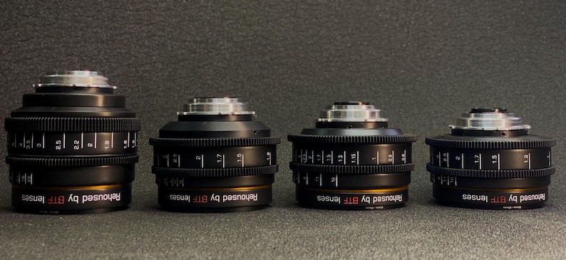 May include: Four black camera lenses with silver accents and gold rings. Each lens has the text "Rehoused by BTF lenses" printed on the side.