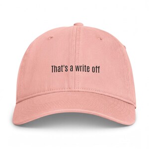 May include: A dusty pink baseball cap featuring the black embroidered text That's a write off centred on the front panel. The cap has a structured crown, a curved brim, and stitched eyelets for ventilation, providing a clean and simple look.