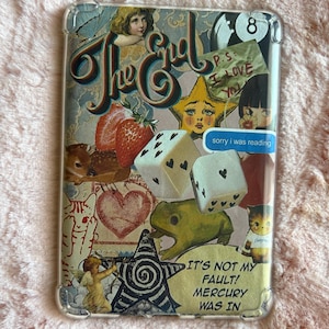 May include: Clear phone case with a collage design. The design includes the words "The End", a crying star, dice, a frog, and the text "IT'S NOT MY FAULT! MERCURY WAS IN". Other elements include a strawberry, a heart, and an angel.