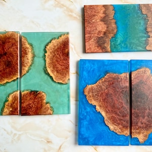 May include: Four wooden cutting boards with blue and green epoxy resin. The boards have a natural wood grain pattern and are perfect for serving cheese, charcuterie, or other appetizers.