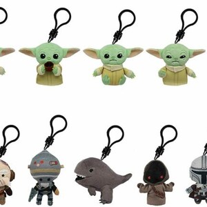 May include: Ten plush keychain characters from the Star Wars franchise. The characters include The Mandalorian, Grogu, and a variety of other characters. The keychains are made of soft, plush fabric and have a black metal clip.
