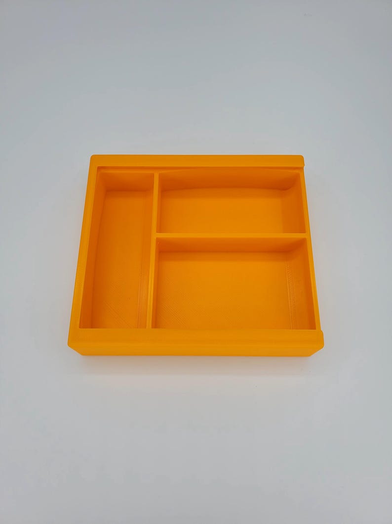 May include: Orange plastic tray with three compartments. The tray is empty.