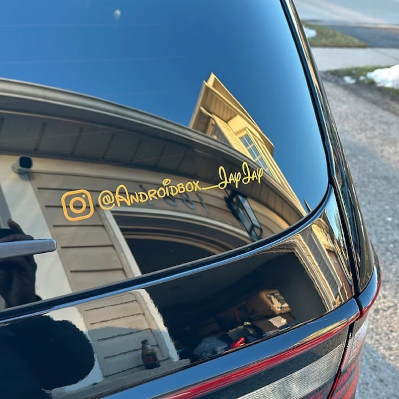 May include: A black car with a gold Instagram logo and the text "@androidbox_JayJay" on the back window.