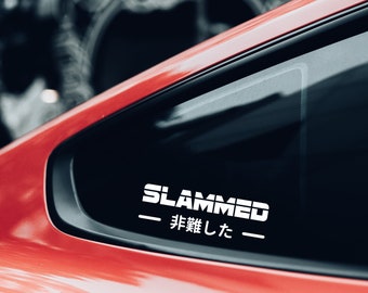 May include: A red car with a white sticker on the rear window that says "SLAMMED - 非難した - "