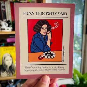 Puede incluir: Una impresión rectangular con una ilustración de Fran Lebowitz fumando un cigarrillo. El texto "FRAN LEBOWITZ SAID" está en la parte superior, con una cita debajo: "There's nothing better for a city than a dense population of angry homosexuals."