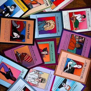 May include: A collection of colorful art prints featuring illustrations of famous women with quotes. The prints include portraits of Dolly Parton, Tina Turner, and Frida Kahlo, among others. Each print has a unique color scheme and design.
