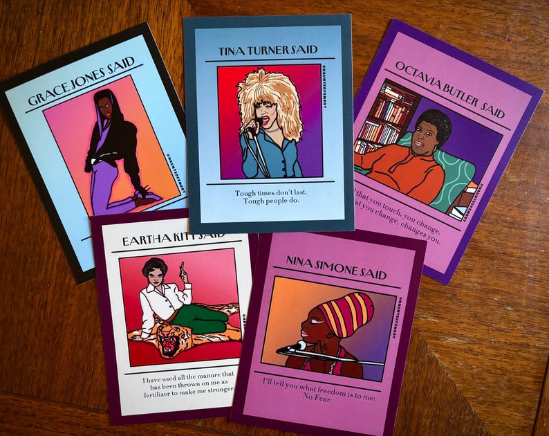 May include: A collection of five art cards featuring illustrations of famous women. Each card has a portrait and a quote attributed to the person. The cards have a colorful design with text that reads "Grace Jones Said", "Tina Turner Said", "Octavia Butler Said", "Eartha Kitt Said", and "Nina Simone Said".
