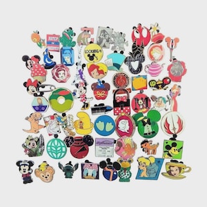 May include: A large collection of colorful metal enamel pins featuring various cartoon characters, symbols, and shapes. The assortment includes icons like Mickey Mouse, Disney princesses, Star Wars logos, and food items, all with diverse designs.