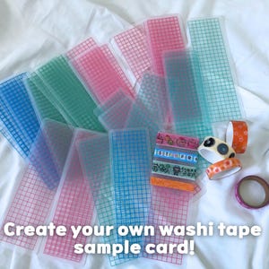 May include: A collection of colorful washi tape sample cards and rolls of decorative tape. The sample cards are transparent with a grid pattern in shades of pink, blue, and green. The text "Create your own washi tape sample card!" is visible.
