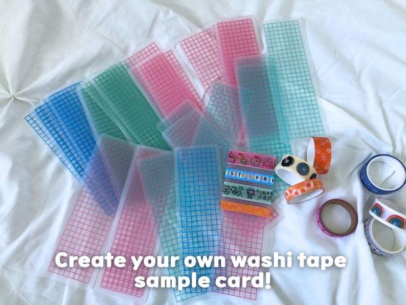 May include: A collection of colorful washi tape sample cards and rolls of decorative tape. The sample cards are transparent with a grid pattern in shades of pink, blue, and green. The text "Create your own washi tape sample card!" is visible.