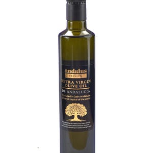 May include: A tall, dark green glass bottle of Andalus Premium Extra Virgin Olive Oil. The black label features gold text, a gold olive tree illustration, and the text: Produced in Ja&eacute;n Andalucia, Olive Oil capital of the world.