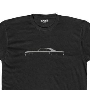 May include: A black t-shirt with a white silhouette of a classic car on the front. The car is a 1969 Dodge Charger.