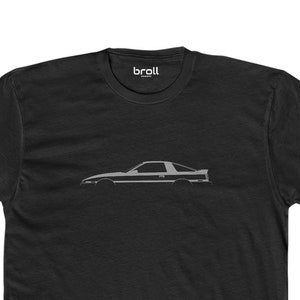 Op de afbeelding: Zwart T-shirt met een grijs silhouet van een Toyota Supra.
